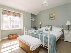 a bedroom with a bed and a window at Primrose Cottage in Penryn