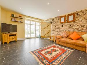 a living room with a couch and a flat screen tv at The Cider Barn at Home Farm in Wembury