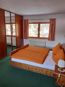 um quarto com uma cama de madeira e 2 janelas em Landhaus-Königsberg, Vorberg 360 em Ramsau am Dachstein
