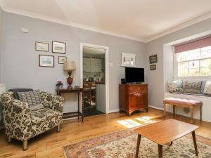 a living room with a couch and a table at Primrose Cottage in Penryn