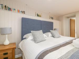 a bedroom with two beds and a blue headboard at The Bolthole in Crantock