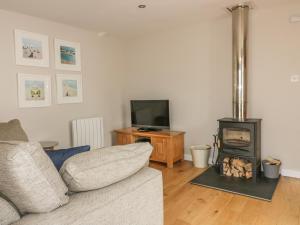 a living room with a couch and a wood stove at The Bolthole in Crantock