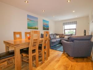 a living room with a table and chairs and a couch at The Beach Hut in Crantock