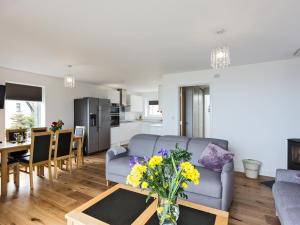 Una sala de estar con un sofá y una mesa con flores. en Godrevy, en St Ives