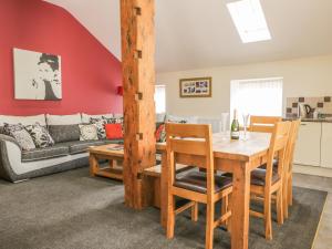 a dining room and living room with a table and chairs at Little Byre Cottage in Sutton