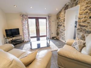 a living room with two couches and a tv at Bothi in Bala