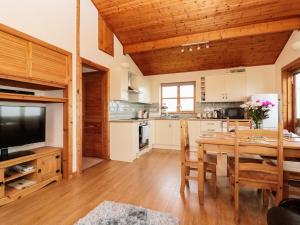 een keuken en eetkamer met een houten plafond bij Cabin in Budock Water