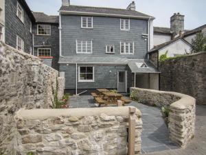 una pared de piedra frente a una casa en The Armourers Forge, en Ashburton