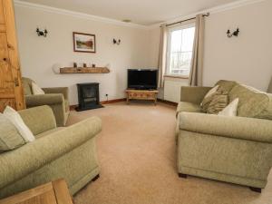 uma sala de estar com dois sofás e uma televisão em 1 Park Nook Close em Waberthwaite