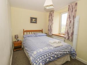 a bedroom with a bed and a window at 2 Park Nook Close in Waberthwaite
