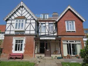 una casa de ladrillo con un banco rojo delante de ella en Swanage Bay Apartment, en Swanage