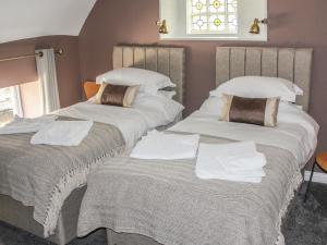 two beds with towels on them in a room at The Little Flat in Barnard Castle