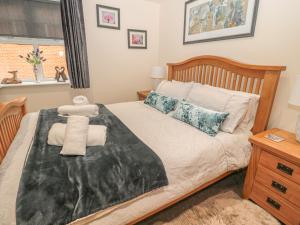 a bedroom with a bed with towels on it at River Cottage in Morpeth