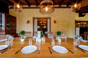 a large wooden table with white plates and silverware at Archontiko Liamas in Stavros