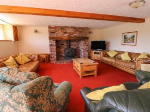a living room with couches and a fireplace at Glanyrafon in Rhayader