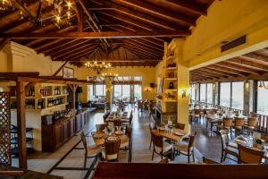 a restaurant with wooden tables and chairs and windows at Archontiko Liamas in Stavros