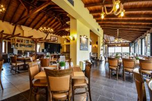 a restaurant with wooden tables and chairs and a bar at Archontiko Liamas in Stavros
