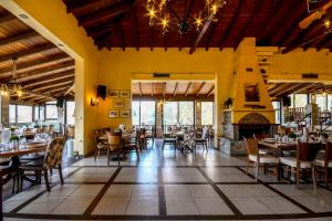 a restaurant with tables and chairs and a fireplace at Archontiko Liamas in Stavros