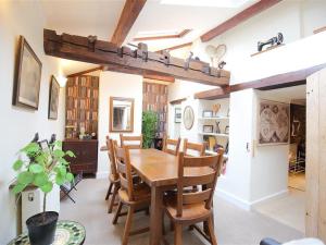 a dining room with a wooden table and chairs at Pike Cottage in Stow on the Wold