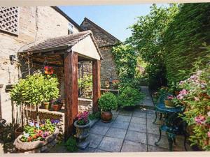 a garden with potted plants on a patio at Pike Cottage in Stow on the Wold