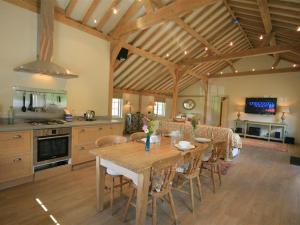 a kitchen and dining room with a wooden table and chairs at West Barn in Woodstock