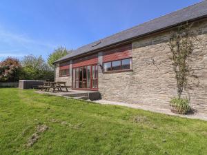 a stone house with a picnic table in front of it at Glanyrafon in Rhayader