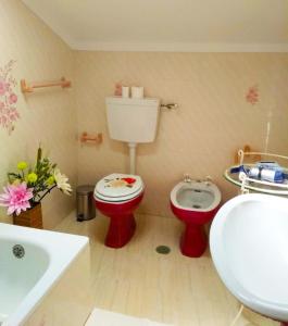 een badkamer met een rood toilet en een wastafel bij Independent house near Estoril with terrace in São Domingos de Rana