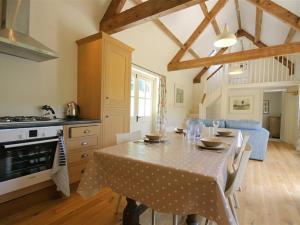 a kitchen and dining room with a table with chairs at Upper Mill Barn in Quenington