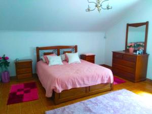 een slaapkamer met een bed, een dressoir en een spiegel bij Independent house near Estoril with terrace in São Domingos de Rana