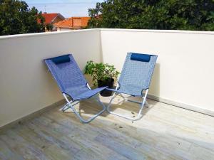 twee blauwe stoelen naast een muur bij Independent house near Estoril with terrace in São Domingos de Rana