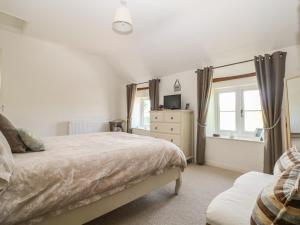 1 dormitorio con cama y ventana en Appin Cottage, en Shipton under Wychwood