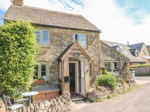 an old stone house with a wooden door at Appin Cottage in Shipton under Wychwood