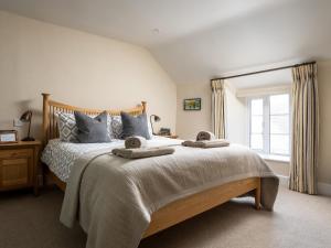 a bedroom with a large bed with two towels on it at Orchard House in Moreton in Marsh