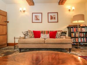 a living room with a couch with pillows on it at Bull Cottage in Burford
