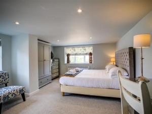 a bedroom with a large white bed and a window at The Granary in Bledington