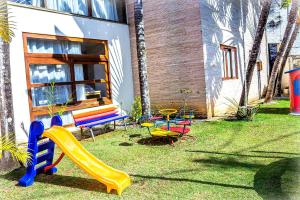 a yard with a playground with a slide and a bench at Pousada L'essence in Paraty
