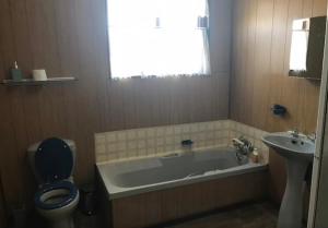 a bathroom with a tub and a toilet and a sink at Fly Shack in Dullstroom
