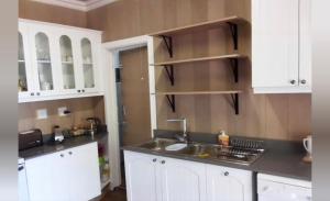 a kitchen with white cabinets and a sink at Fly Shack in Dullstroom