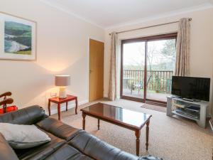 a living room with a couch and a flat screen tv at Little Waycroft in Dawlish