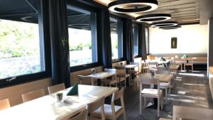 a dining room with tables and chairs and windows at Der Löwen, Löwen Betriebs- und Management GmbH in Bludenz