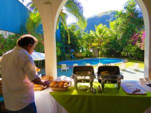 a man standing in front of a table with food at Chanchamayo Inn Hotel in La Merced