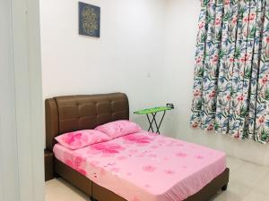a bed with pink sheets and pink pillows in a room at Bismillah Homestay Muslem NETFLIX UNIFI HIGH SPEED in Kamunting