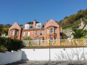 a large brown brick house with a wooden fence at Tan Tabin in Llandudno