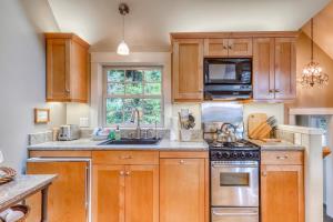 una cocina con armarios de madera y fregadero en Serene Redwood Retreat, en Arcata