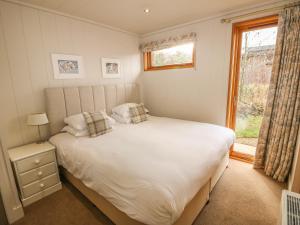 a bedroom with a large white bed and a window at Hambleton in Cottesmore