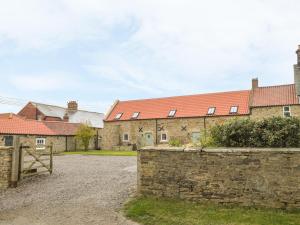 a building with red roofs and a stone wall at Cross Cottage in Durham