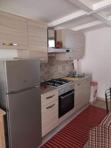 uma cozinha com um frigorífico de aço inoxidável e um fogão em Villa Engi em Arenella