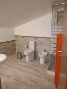 uma casa de banho com um WC e um bidé em Villa Engi em Arenella