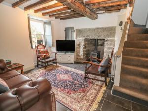 a living room with a couch and a fireplace at College Cottage in Corwen