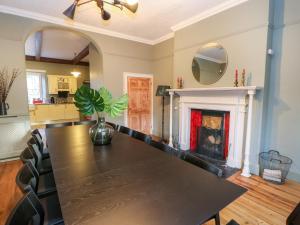 uma sala de jantar com uma mesa e uma lareira em Stepping Stones em Richmond
